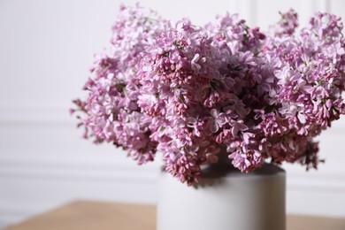 Photo of Beautiful lilac flowers in vase indoors, closeup