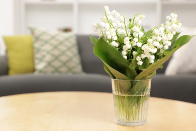 Photo of Bouquet of beautiful lily-of-the-valley on wooden table indoors, closeup. Space for text