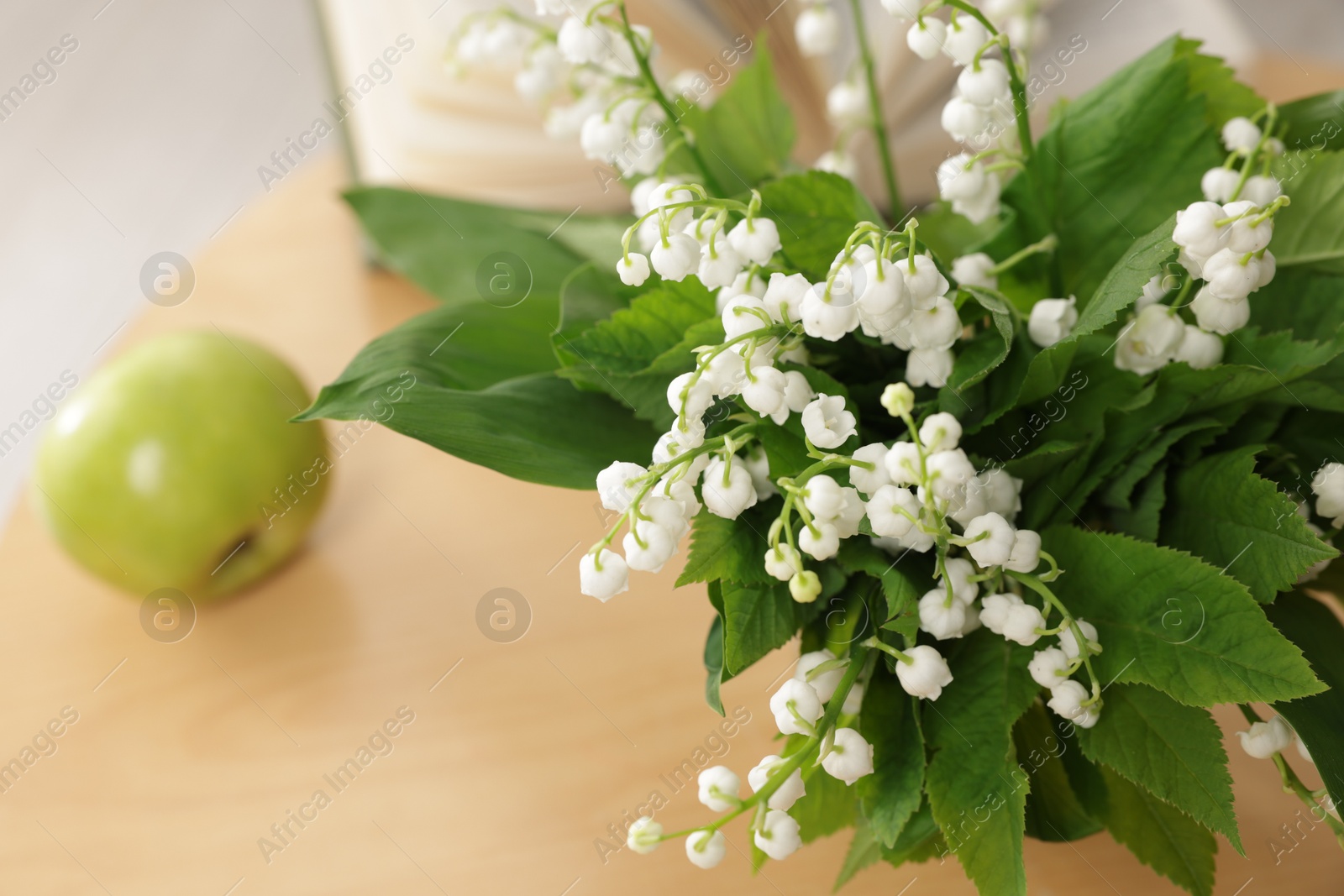 Bouquet of beautiful lily-of-the-valley on table indoors, closeup Photo of Bouquet of beautiful lily-of-the-valley on table indoors, closeup