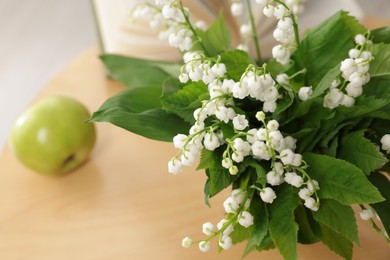 Photo of Bouquet of beautiful lily-of-the-valley on table indoors, closeup