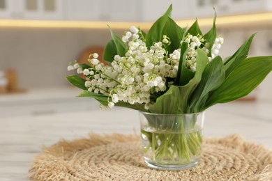 Photo of Bouquet of beautiful lily-of-the-valley on white marble table in kitchen, closeup
