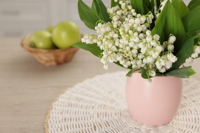 Photo of Bouquet of beautiful lily-of-the-valley on table indoors, closeup