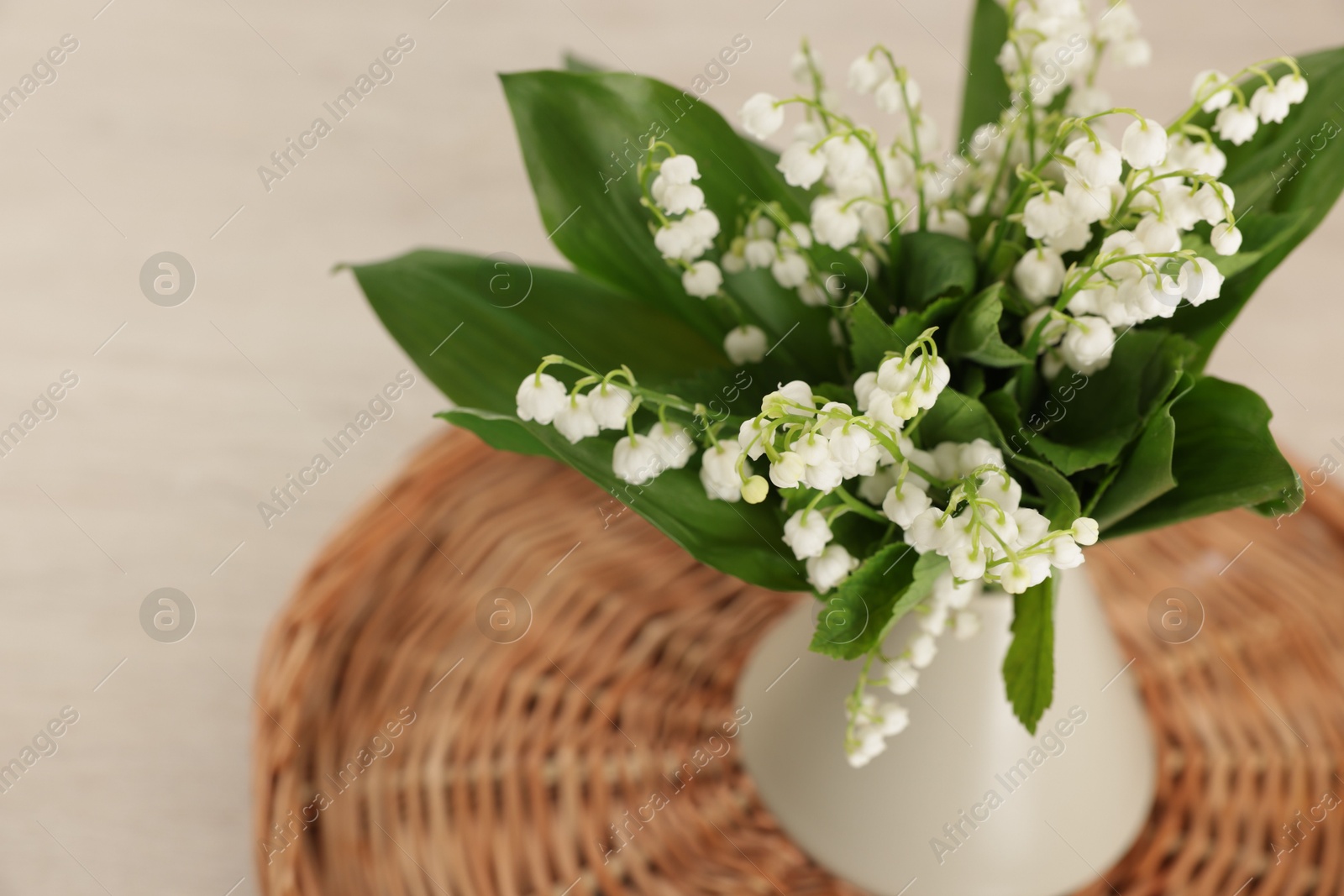 Bouquet of beautiful lily-of-the-valley in vase on table, closeup Photo of Bouquet of beautiful lily-of-the-valley in vase on table, closeup