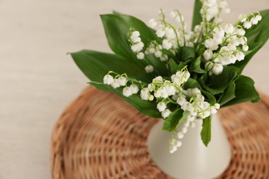 Photo of Bouquet of beautiful lily-of-the-valley in vase on table, closeup