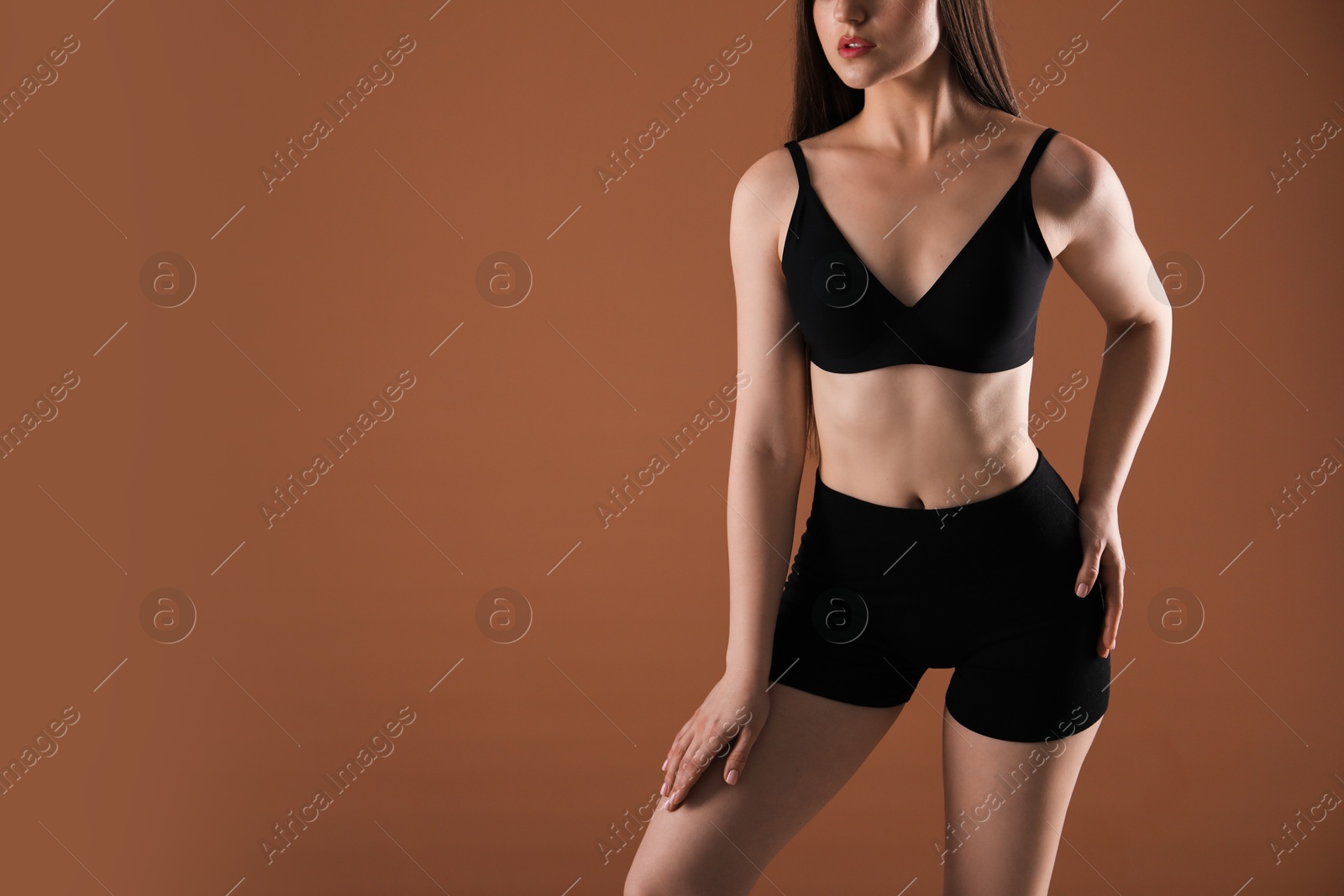 Woman with beautiful body on brown background, closeup. Space for text Photo of Woman with beautiful body on brown background, closeup. Space for text