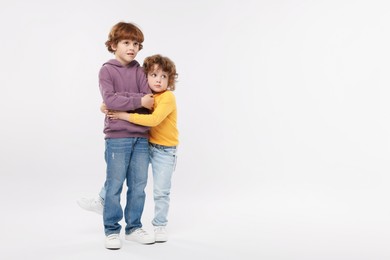Photo of Cute little brothers hugging on white background