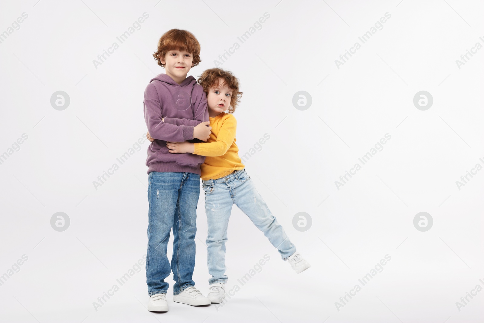 Cute little brothers hugging on white background Photo of Cute little brothers hugging on white background