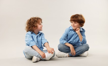 Photo of Cute little brothers together on light background