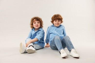Photo of Cute little brothers together on light background