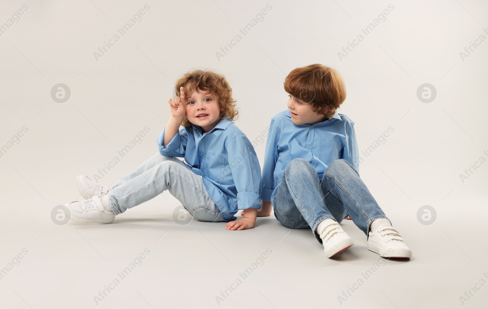 Cute little brothers together on light background Photo of Cute little brothers together on light background