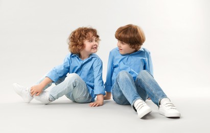 Photo of Cute little brothers together on light background