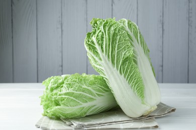 Photo of Fresh Chinese cabbages on white wooden table