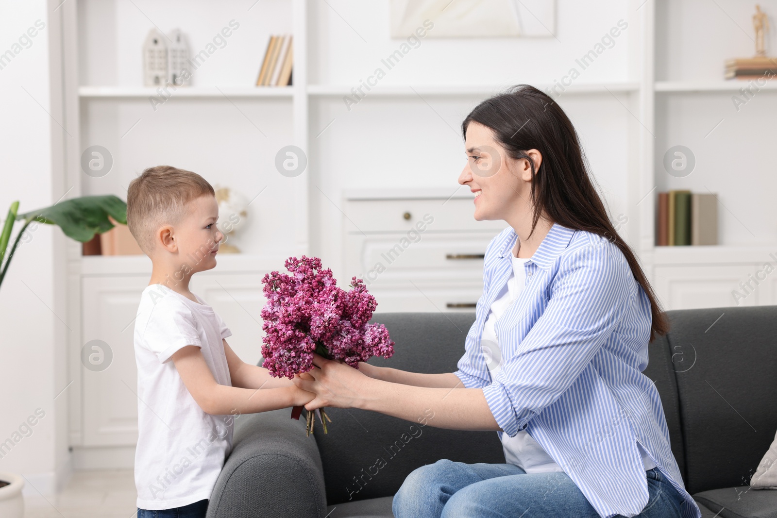 Mother and her son with bouquet of lilac flowers at home Photo of Mother and her son with bouquet of lilac flowers at home