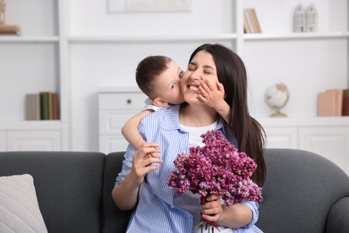 Photo of Mother and her son with bouquet of lilac flowers at home