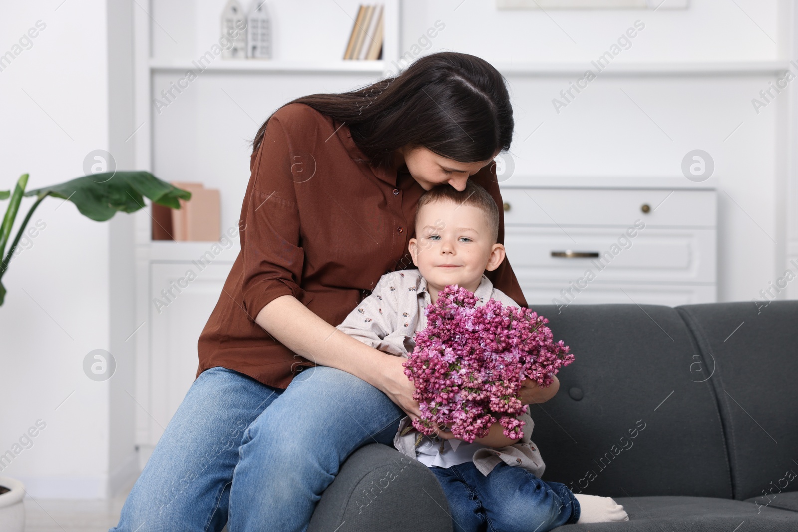 Mother and her son with bouquet of lilac flowers at home Photo of Mother and her son with bouquet of lilac flowers at home