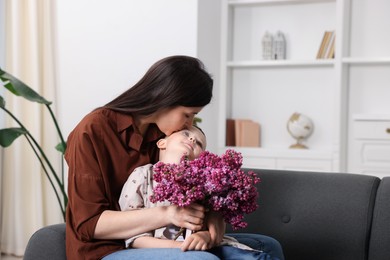 Photo of Mother and her son with bouquet of lilac flowers at home, space for text