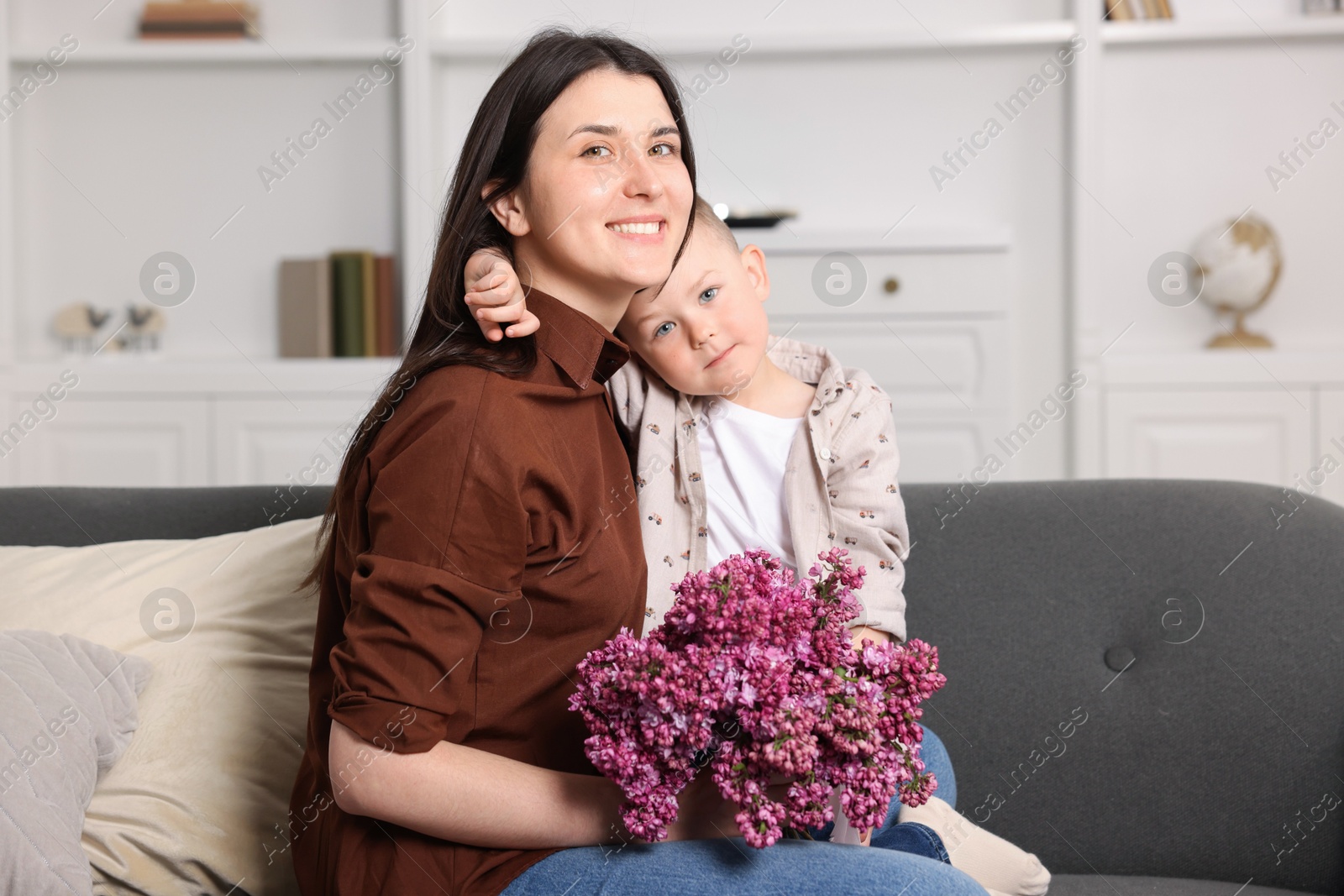 Mother and her son with bouquet of lilac flowers at home Photo of Mother and her son with bouquet of lilac flowers at home