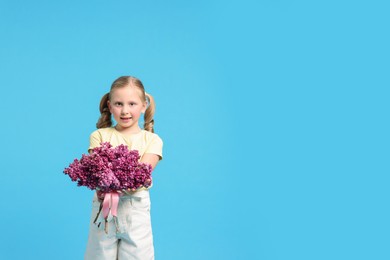 Photo of Little girl with bouquet of lilac flowers on light blue background, space for text