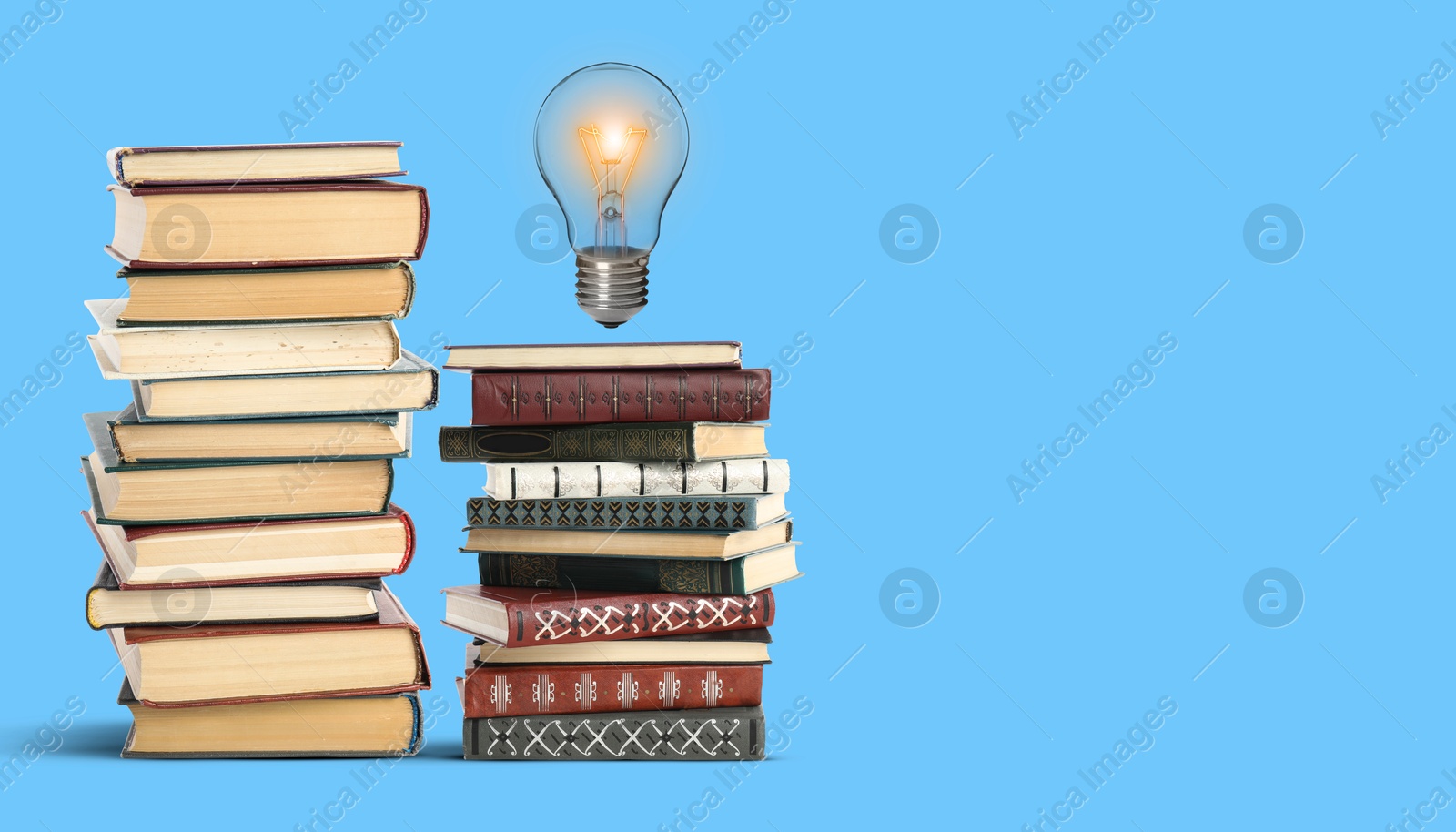 Idea and knowledge. Light bulb in air over books on light blue background, space for text. Banner design Image of Idea and knowledge. Light bulb in air over books on light blue background, space for text. Banner design