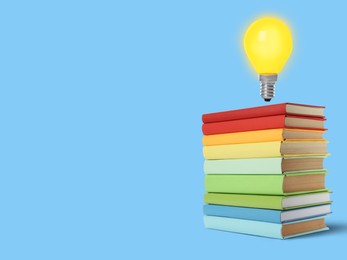Image of Light bulb in air over stack of books on light blue background, space for text. Idea and knowledge