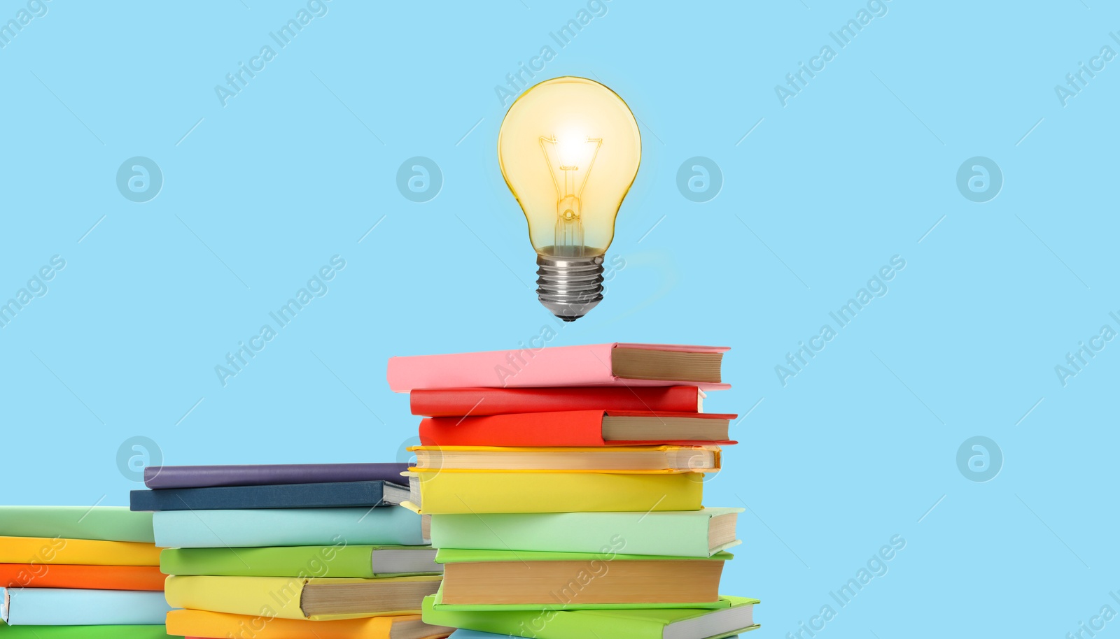 Idea and knowledge. Light bulb in air over books on light blue background. Banner design Image of Idea and knowledge. Light bulb in air over books on light blue background. Banner design