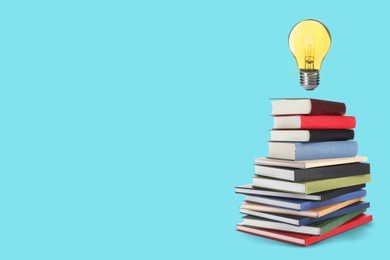 Image of Idea and knowledge. Light bulb in air over stack of books against turquoise background, space for text