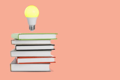 Image of Idea and knowledge. Light bulb in air over stack of books on coral background, space for text