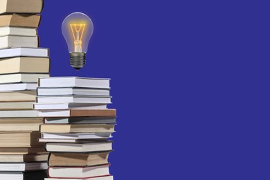 Image of Idea and knowledge. Light bulb in air over books on blue background, space for text