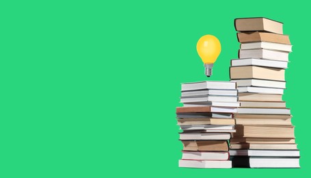 Image of Idea and knowledge. Light bulb in air over books on green background, space for text. Banner design