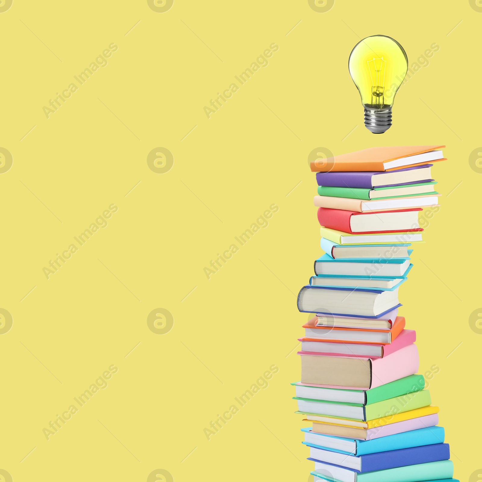 Light bulb in air over stack of books on yellow background, space for text. Idea and knowledge Image of Light bulb in air over stack of books on yellow background, space for text. Idea and knowledge