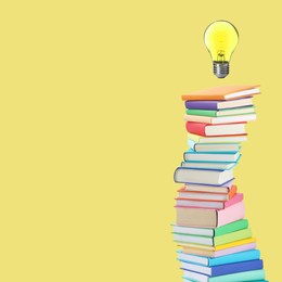 Image of Light bulb in air over stack of books on yellow background, space for text. Idea and knowledge