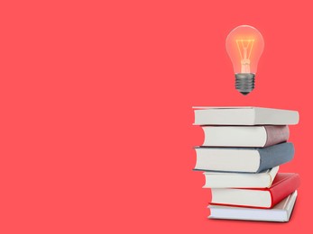 Image of Light bulb in air over stack of books on pale red background, space for text. Idea and knowledge