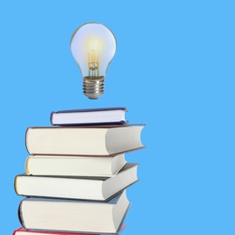 Image of Light bulb in air over stack of books on light blue background. Idea and knowledge