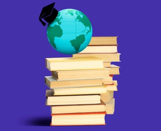 Image of Graduate cap illustration and globe over books on blue background