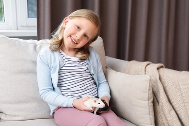 Photo of Little girl with cute rats on sofa at home, space for text