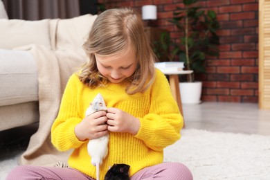 Photo of Little girl with cute rats on floor at home, space for text