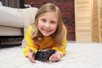 Photo of Little girl with cute rats on floor at home