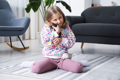 Photo of Little girl with cute rats on floor at home