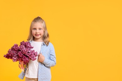 Photo of Little girl with bouquet of lilac flowers on yellow background, space for text