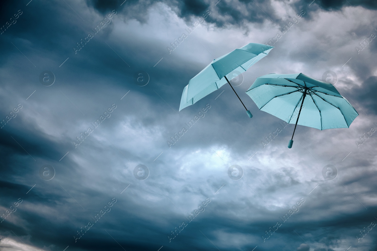 Light blue umbrellas flying in cloudy sky. Stormy weather Image of Light blue umbrellas flying in cloudy sky. Stormy weather