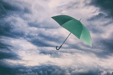 Image of Green umbrella flying in cloudy sky under heavy rain. Stormy weather