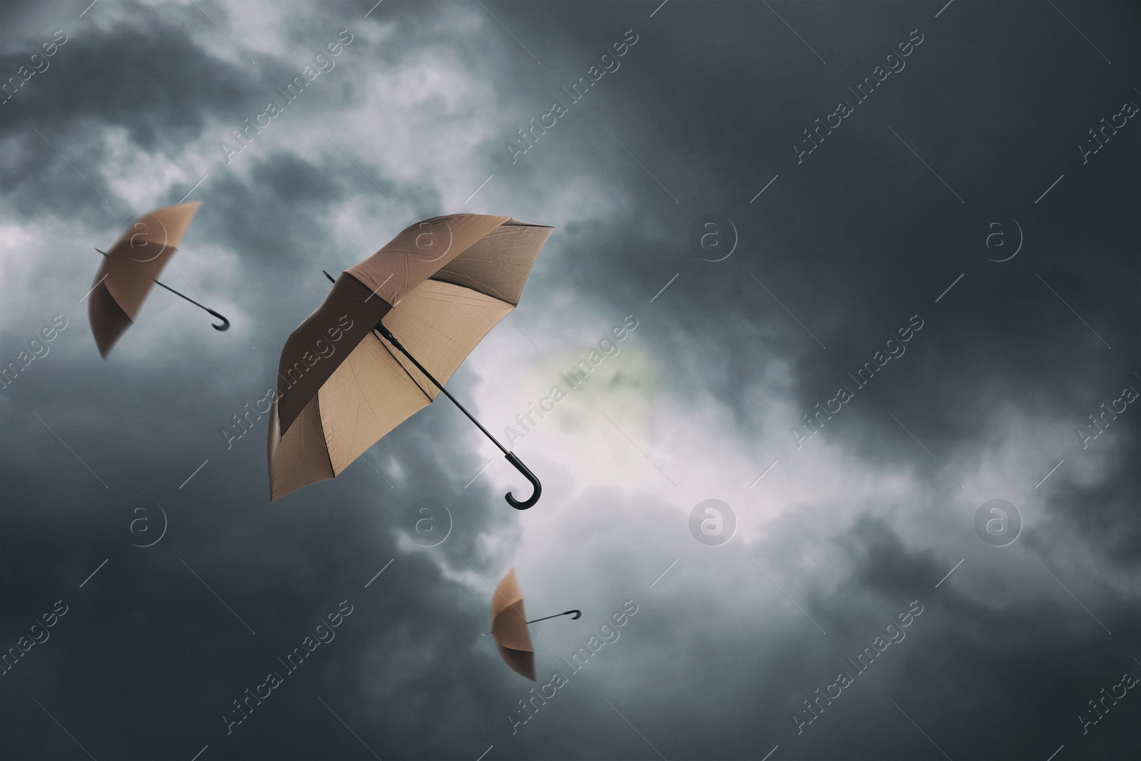 Brown umbrellas flying in dark cloudy sky. Stormy weather Image of Brown umbrellas flying in dark cloudy sky. Stormy weather