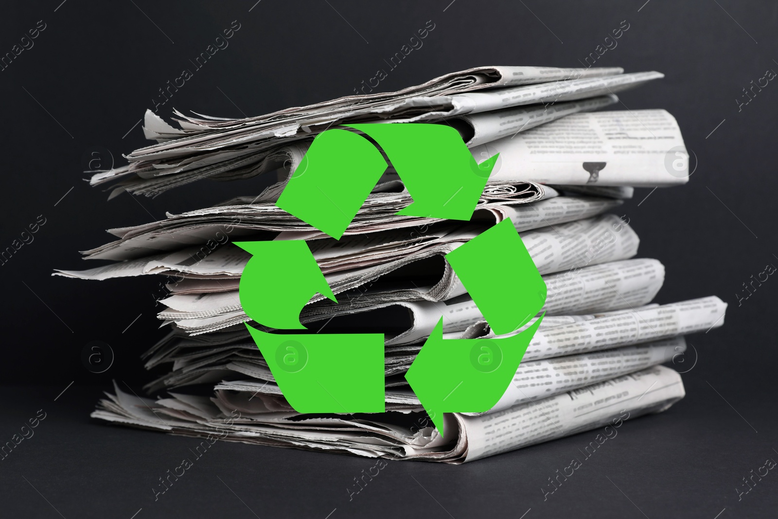 Recycling symbol and many newspapers on grey table. Eco-friendly lifestyle, reusing Image of Recycling symbol and many newspapers on grey table. Eco-friendly lifestyle, reusing