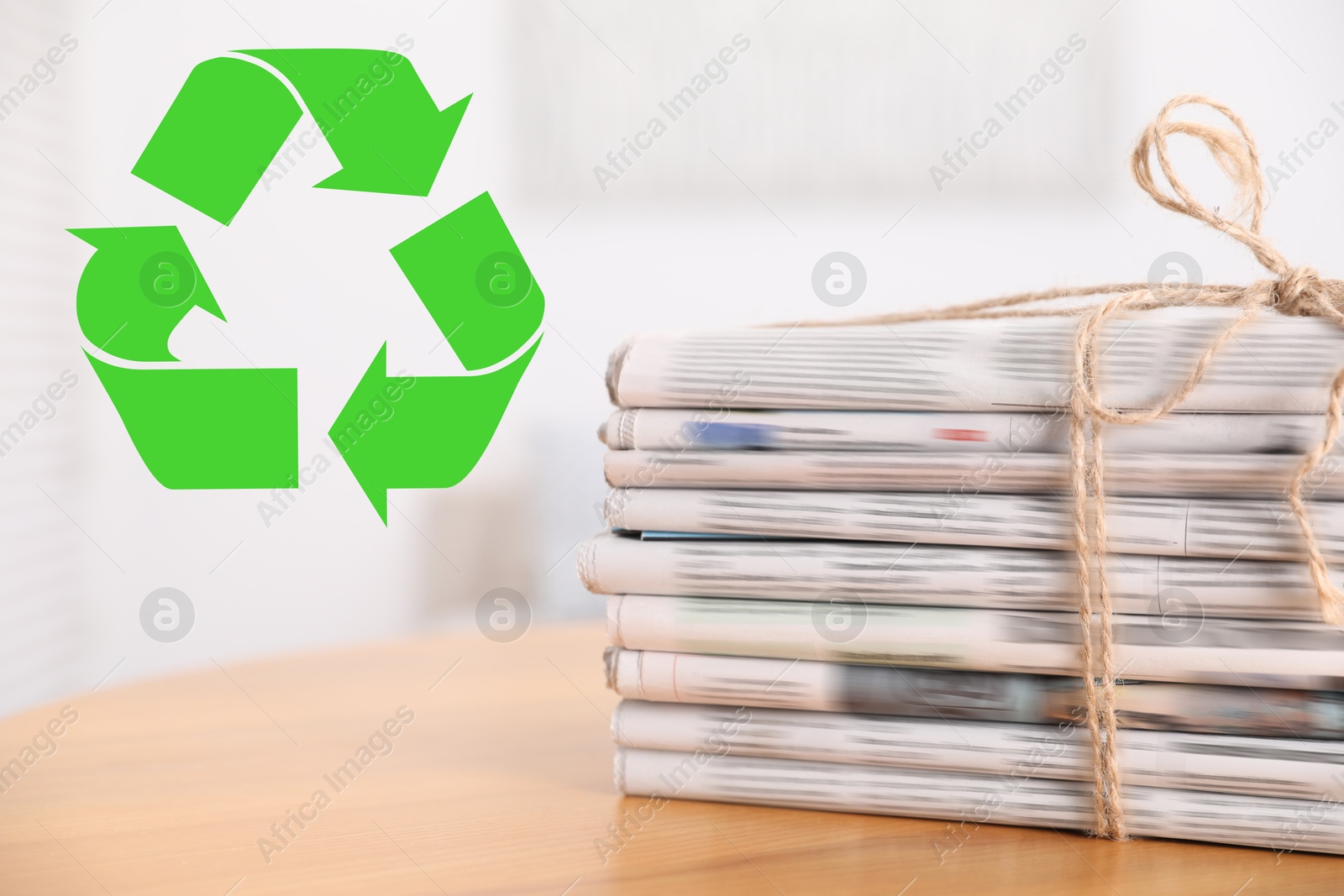 Recycling symbol and stack of tied newspapers on wooden table, closeup. Eco-friendly lifestyle, reusing Image of Recycling symbol and stack of tied newspapers on wooden table, closeup. Eco-friendly lifestyle, reusing