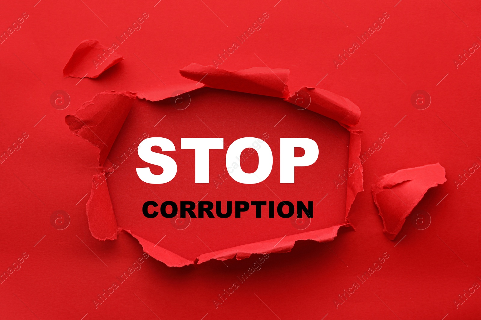 Words Stop Corruption, view through hole in red paper Image of Words Stop Corruption, view through hole in red paper