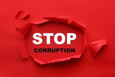 Image of Words Stop Corruption, view through hole in red paper