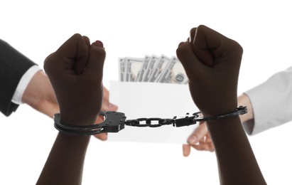 Image of Stop corruption. Woman taking bribe from man on white background, closeup. Her hands with handcuffs as result of unlawful actions