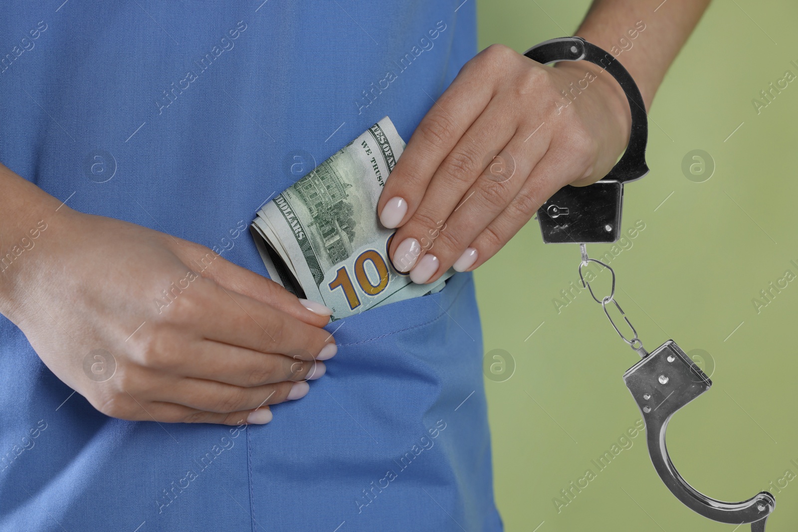 Stop corruption. Doctor hiding dollars into her pocket on green background, closeup. Her hand with handcuffs symbolizing unlawful actions Image of Stop corruption. Doctor hiding dollars into her pocket on green background, closeup. Her hand with handcuffs symbolizing unlawful actions