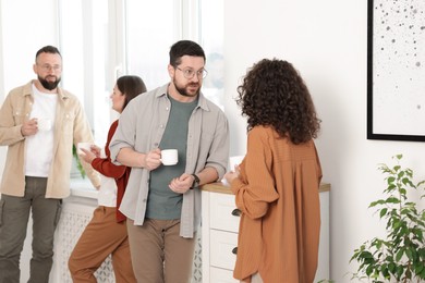 Photo of Colleagues chatting during coffee break in office