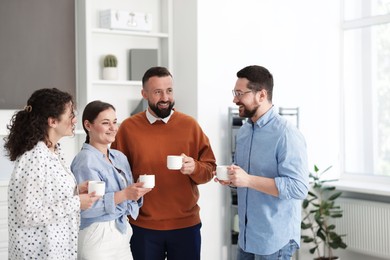 Photo of Colleagues chatting during coffee break in office